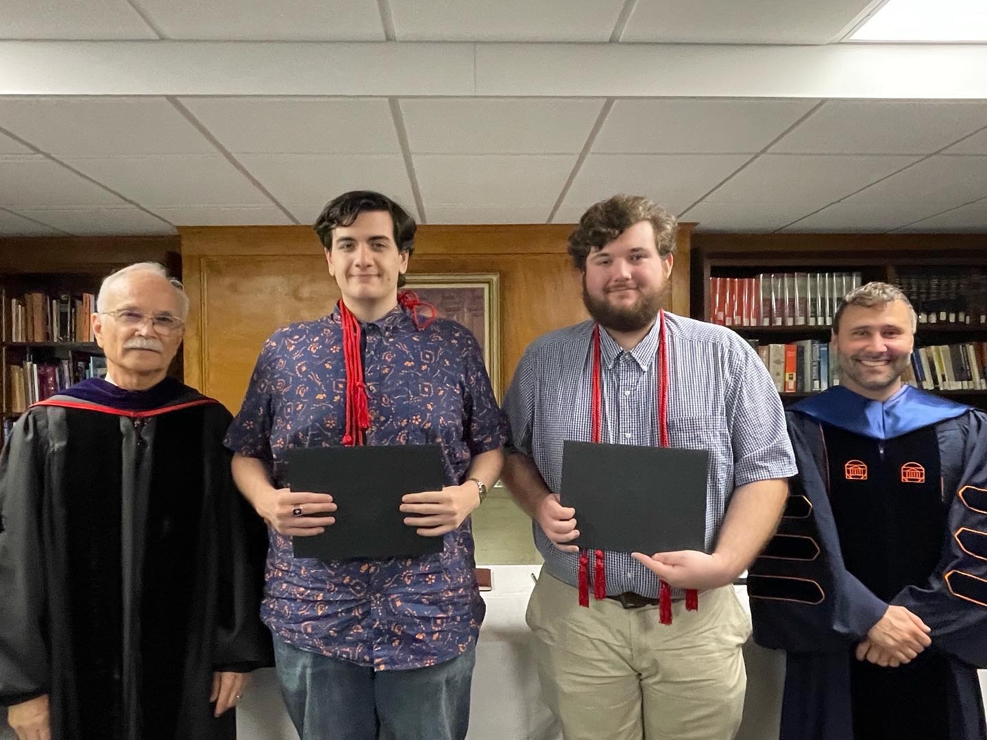 two students being inducted alongside two professors